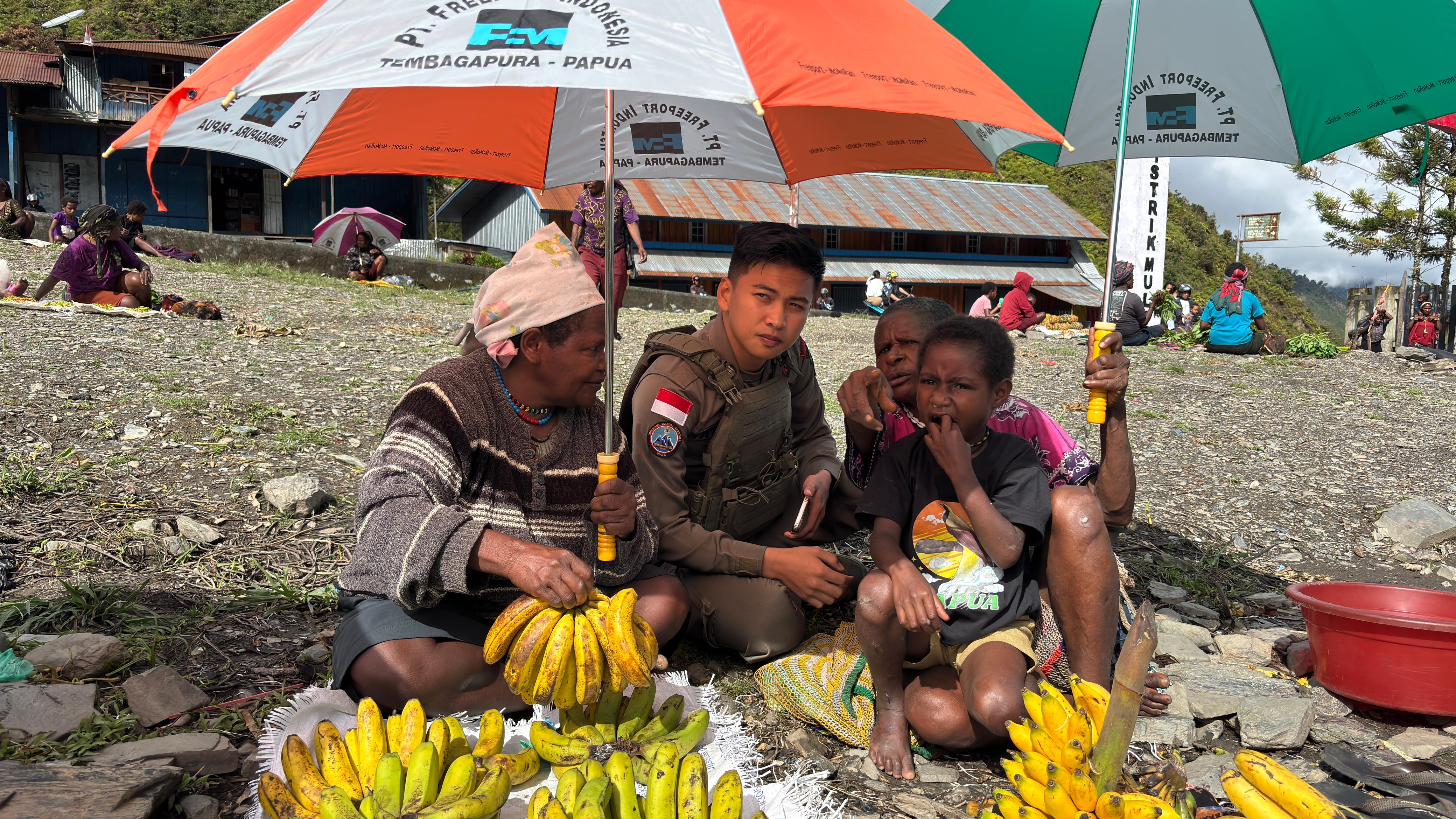 Senyum Mama-Mama Papua Saat Bripda. Rafly Personel Ops Damai Cartenz-2025 Ulurkan Payung