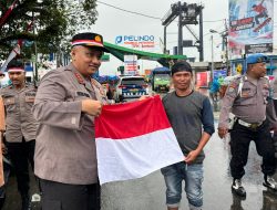 Polresta Ambon Bagikan 200 Bendera Merah Putih di Tengah Hujan Sambut HUT ke-80 RI